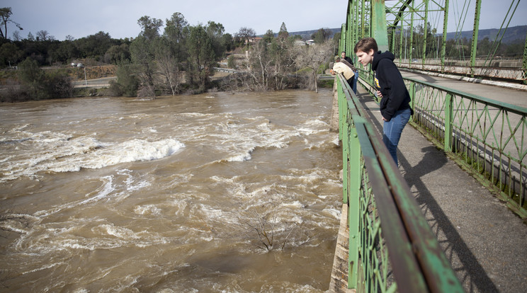Néhány hátramaradt ember a Feather folyót nézi egy hídról a kaliforniai Oroville-ben / Fotó: MTI