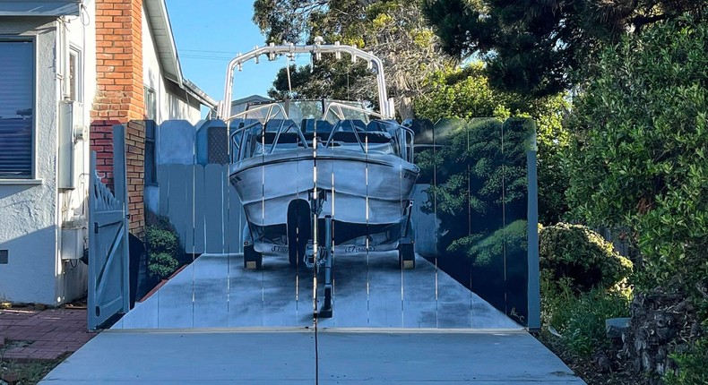 After Etienne Constable was told to hide his boat from the street, he hired friend and neighbor Hanif Panni to paint his boat on the new fence.Courtesy of Hanif Panni / @hanifwondir