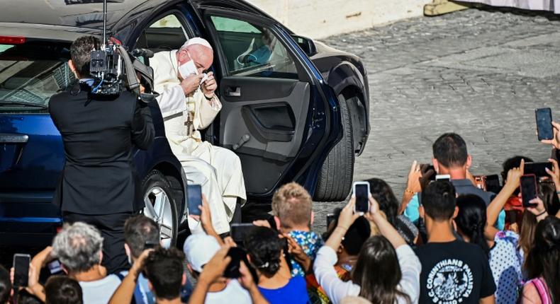 Pope Francis quickly removed his face mask as he emerged from his car