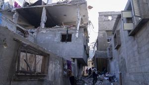 Palestinians inspect a damaged building following Israeli airstrikes on the town of Khan Younis, Gaza, on Dec. 3, 2023.