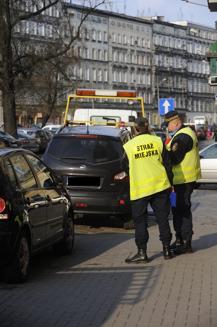 Strażnicy miejscy z Wrocławiu przy odholowywanym samochodzie