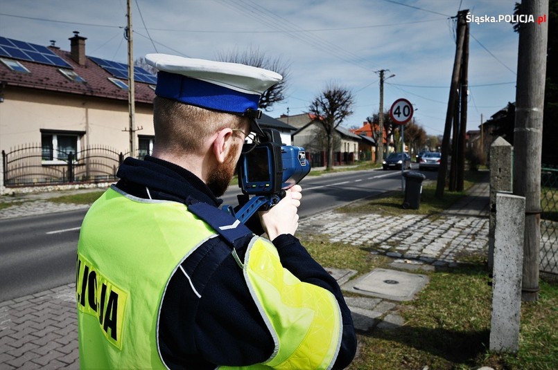 Policjant kontroluje prędkość kierowców przezd przejściem dla pieszych