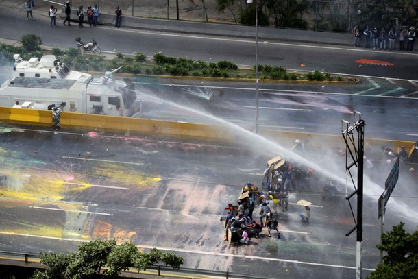 Opposition supporters clash with riot security forces while rallying against President Nicolas Madur