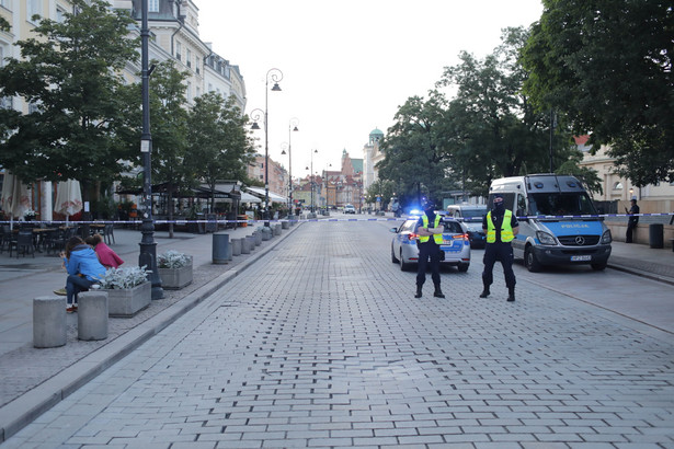 Warszawa, 11.07.2022. Policjanci zabezpieczają ewakuowany teren Krakowskiego Przedmieścia w Warszawie, 11 bm. Policja ewakuowała uczestników zgromadzenia i osoby przebywające w promieniu 200 metrów od budynku przy Krakowskim Przedmieściu 64. Mężczyzna wyjął z plecaka i położył na ziemi niebezpieczny przedmiot. Policyjni antyterroryści zabezpieczyli pocisk o dużej sile rażenia. (sko) PAP/Albert Zawada