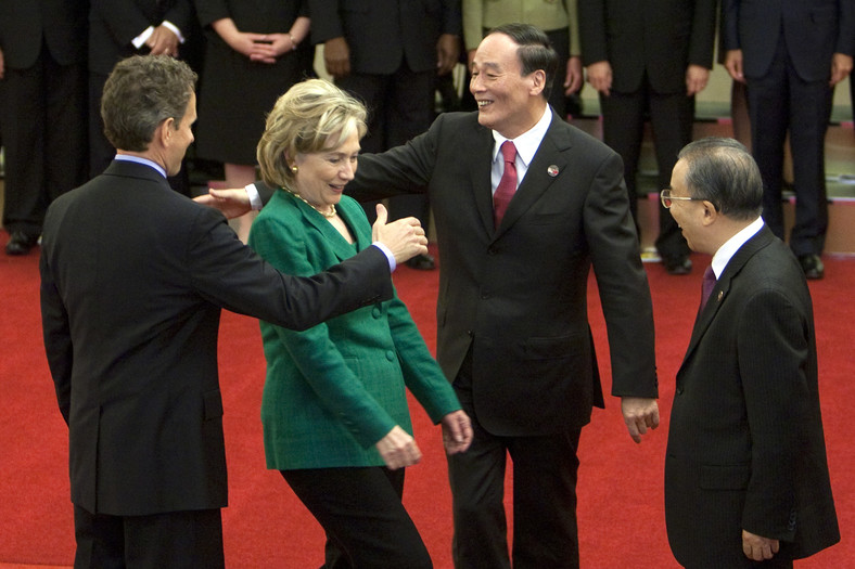 Hilary Clinton, amerykańska sekretarz stanu „schwytana” przez witających się od lewej Timothego Leithnera, amerykańskiego sekretarza skarbu oraz Wang Qishan, chińskiego wicepremiera, 24 maja 2010.