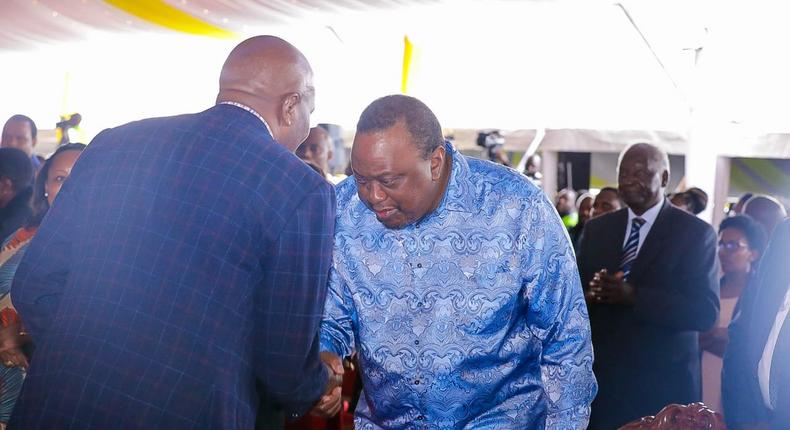 Retired President Uhuru Kenyatta greets CS Moses Kuria during the Episcopal Ordination for Bishops elect Simon Peter Kamomoe and Wallace Ng'ang'a at St Mary's Msongari.