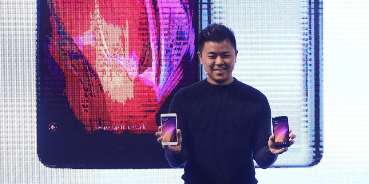 Donovan Sung, Director of Product Management and Marketing at China's mobile company Xiaomi, holds mobile phones as he poses for a photo during a presentation to celebrate the entry of the company into the Mexican market, in Mexico City