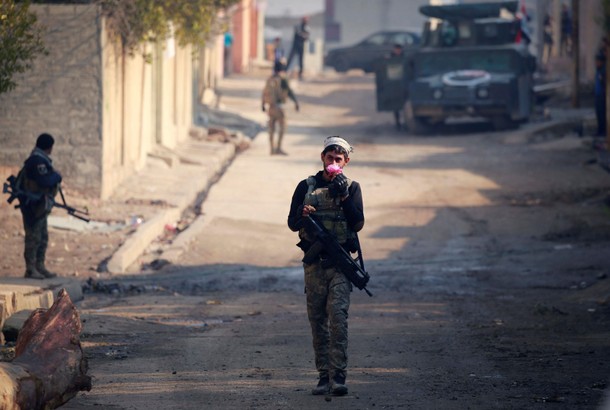 A member of Iraqi rapid response forces holds flower during battle with Islamic State militants in t