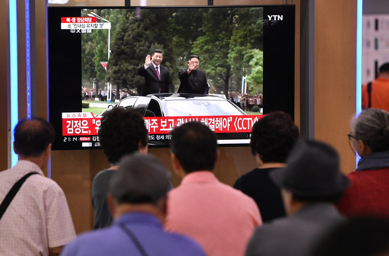 Zdjęcie programu informacyjnego pokazującego spotkanie przewodniczącego Chińskiej Republiki Ludowej Xi Jinpinga i przywódcy Korei Północnej Kim Dzong Una, 2019 r.