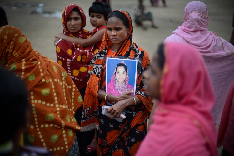 Rodziny przynoszą zdjęcia swoich bliskich - pracowników, który w momencie katastrofy byli w budynku