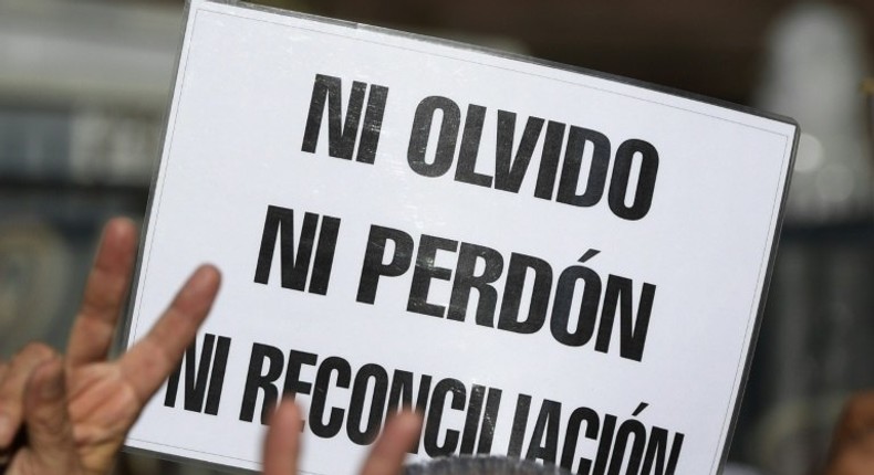 A demonstrator holds a sign reading in Spanish Neither forget nor forgive, nor reconciliation, during the Madres de Plaza de Mayo human rights group's weekly demonstration at the Plaza de Mayo square in Buenos Aires on May 4, 2017