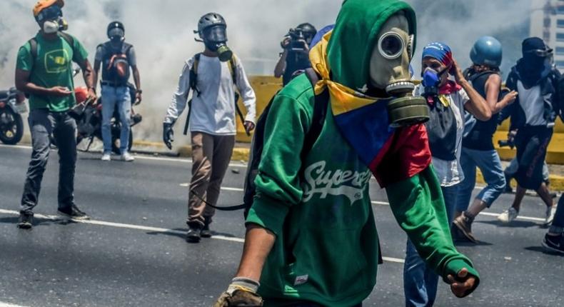 Venezuelan opposition activists clash with riot police during a protest march against President Nicolas Maduro in Caracas on April 26, 2017