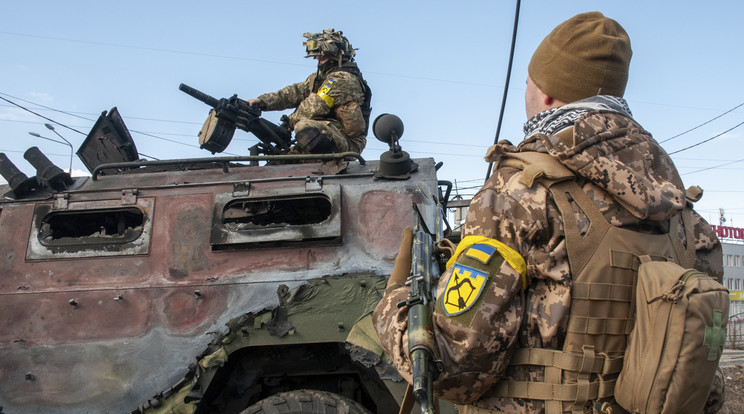 Ukrán katonák vizsgálnak egy kiégett katonai járművet Harkivban 2022. február 27-én / Fotó: MTI/AP/Marienko Andrew