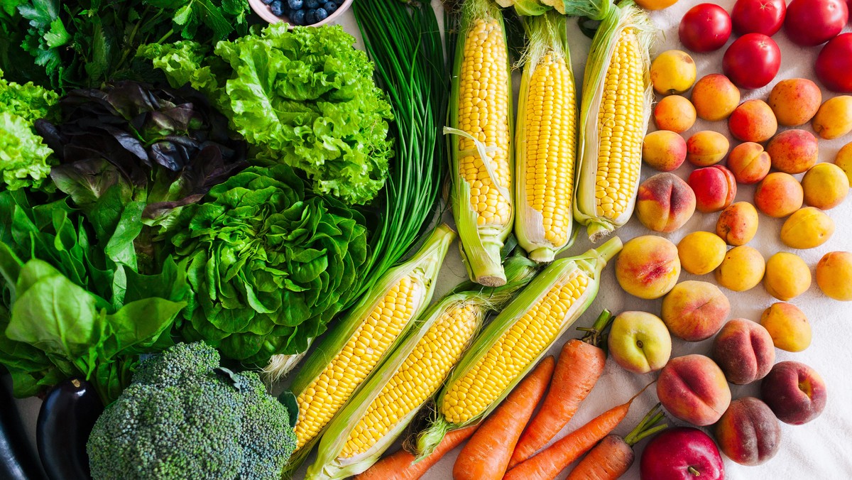 flat lay of different summer fruits, vegetables, greens and berries