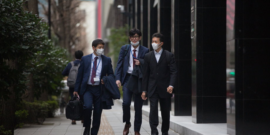 Japońscy pracownicy na ulicach Tokio.