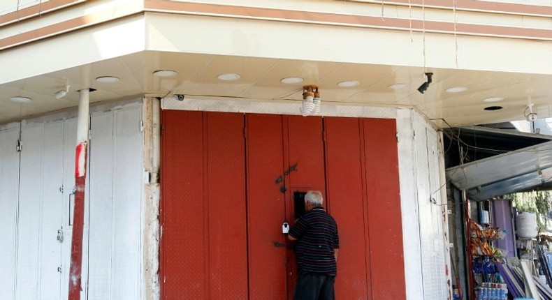 An Iraqi man buys liquor from a shop selling it illegaly through a window in the capital Baghdad on October 23, 2016