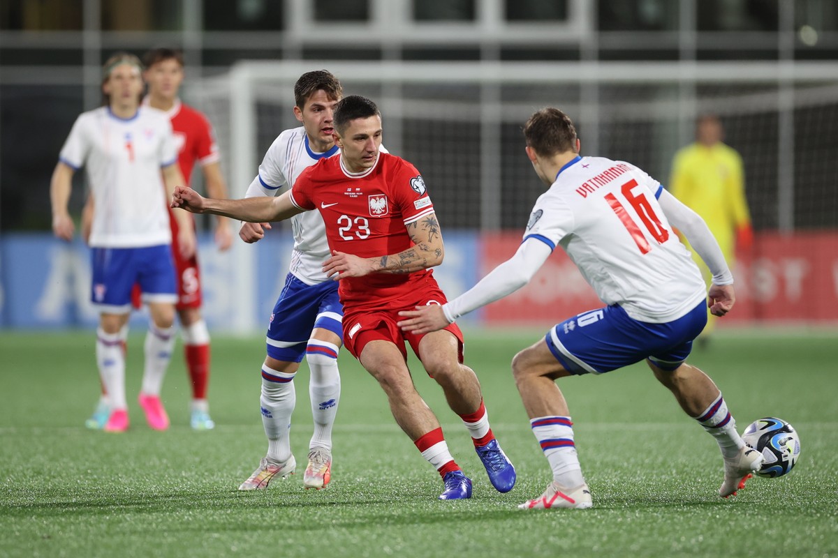 Polak Bartosz Slisz (C) i Gunnar Vatnhamar (P) z Wysp Owczych podczas meczu eliminacyjnego grupy E piłkarskich mistrzostw Europy w Thorshavn