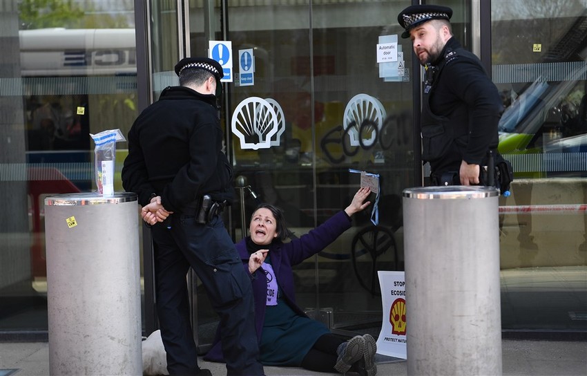 Demonstrantkinja se zalepila za vrata zgrade "Šela" tokom klimatskog protesta u Londonu 15. aprila 2019.