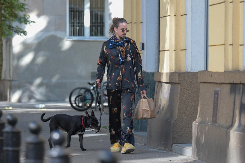 Michał Szpak podczas spaceru z psem w piżamie. 