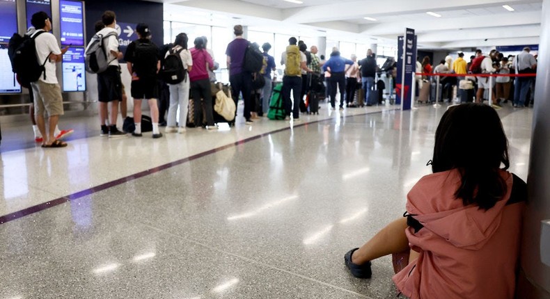 A passenger waits as Delta Air Lines delays and cancellations snarled travel.Mario Tama / Getty Images