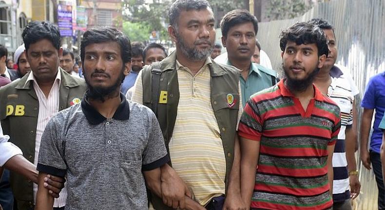 Bangladesh police escort two men accused in the murder of blogger Washiqur Rahman for a court appearance in Dhaka on March 31, 2015