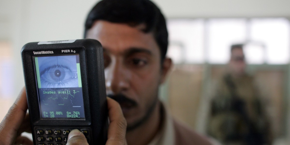 A US Marine takes a retinal scan of a local Fallujah resident.