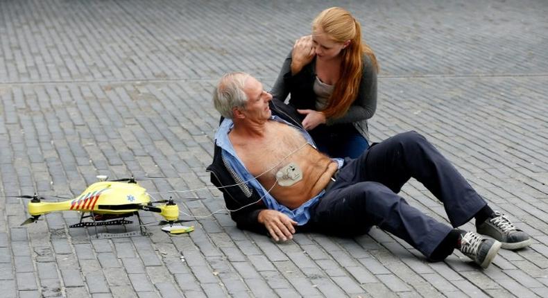 A woman gives a demonstration of an ambulance drone with built in defibrillator at the campus of the Delft Technical University in Delft on October 28, 2014. A Swedish report Tuesday said drones can drastically cut response times for delivering the life-saving equipment to victims.