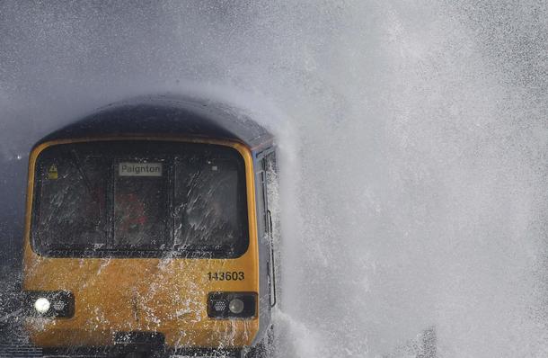 Waves hit a train during heavy seas and high winds in Dawlish in south west Britain