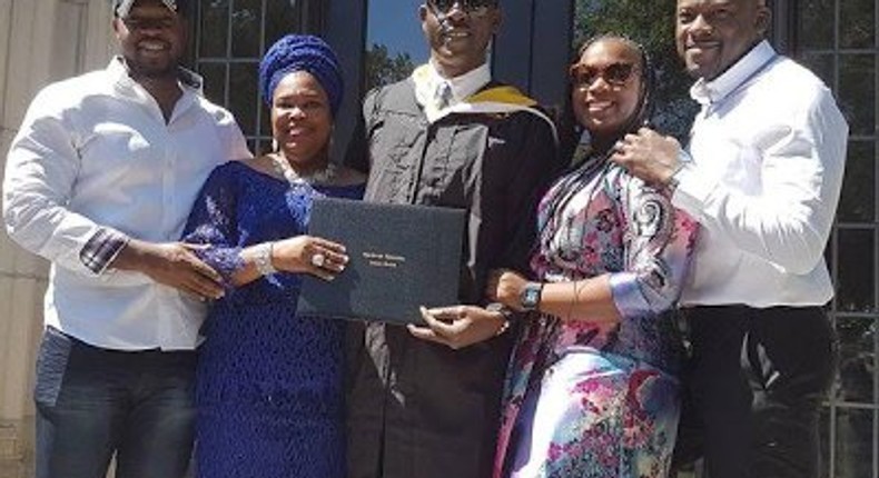 Musiliu Obanikoro flanked by his wife and children at his graduation