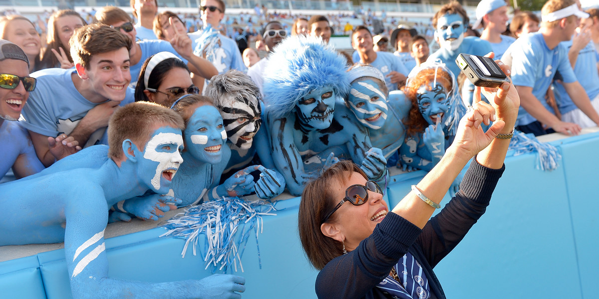 UNC Chancellor Carol Folt with fans at a football game.
