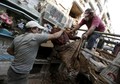 A grave cleaner holds mummified body of woman during exhumation works at the General Cemetery in Guatemala City