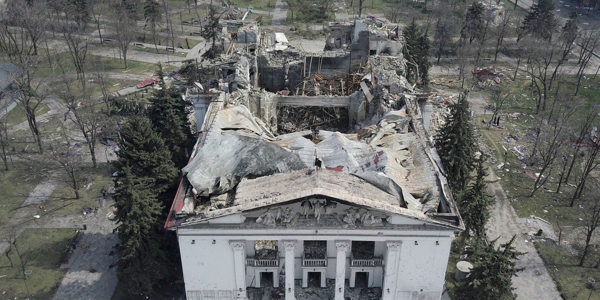 Graves of civilians killed during Ukraine-Russia conflict are seen next to apartment buildings in th