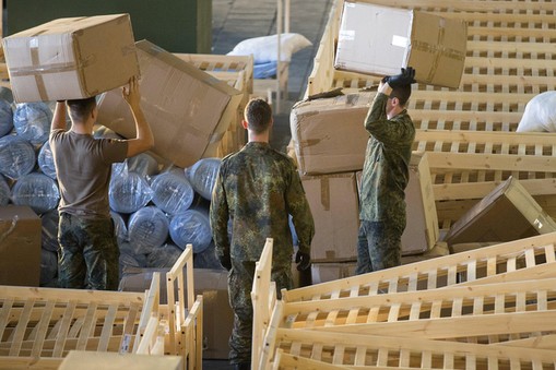 German armed forces Bundeswehr soldiers set up beds for migrants in the hangar of the former Tempelh