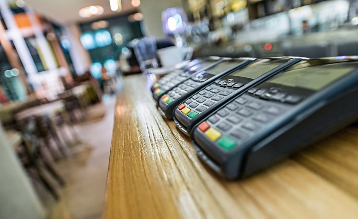 Credit card terminal in modern restaurant, blured background