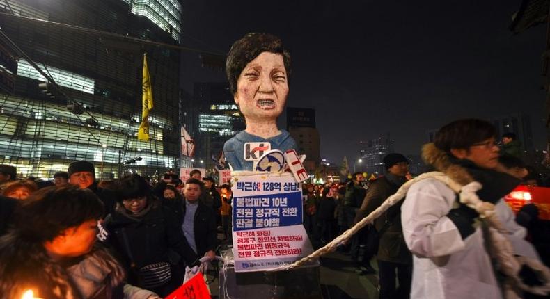 South Korean protesters carry an effigy of President Park Geun-Hye during a rally against the scandal-hit president in central Seoul on December 17, 2016