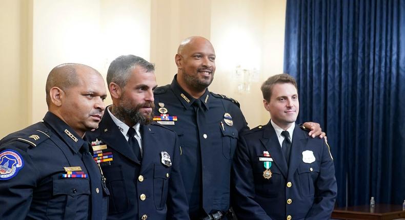 Four police officers who worked during the Capitol riot pose after testifying to a House select committee.
