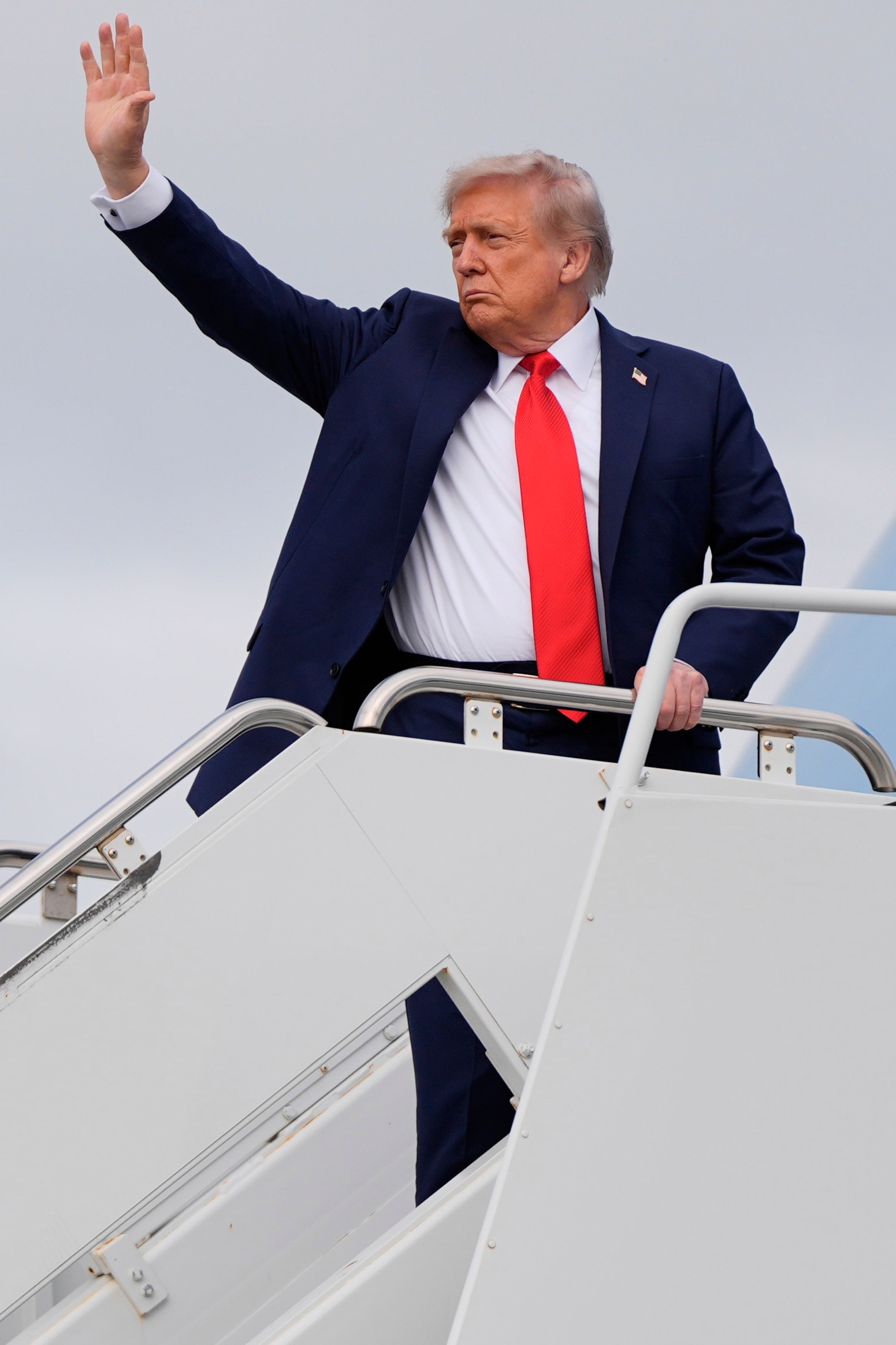 Americký prezident Donald Trump nastupuje do lietadla Air Force One po stretnutí s  ruským prezidentom Vladimirom Putinom.