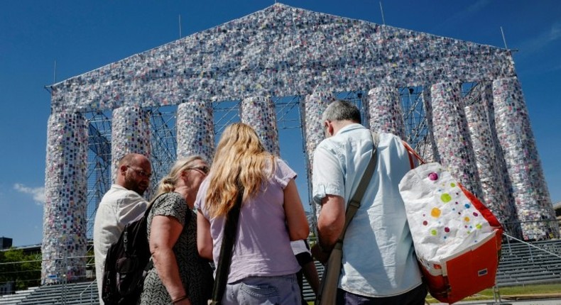 People pause in front of the Parthenon of Books by Argentinian artist Marta Minujin, at the Documenta 14 art exhibition in Kassel