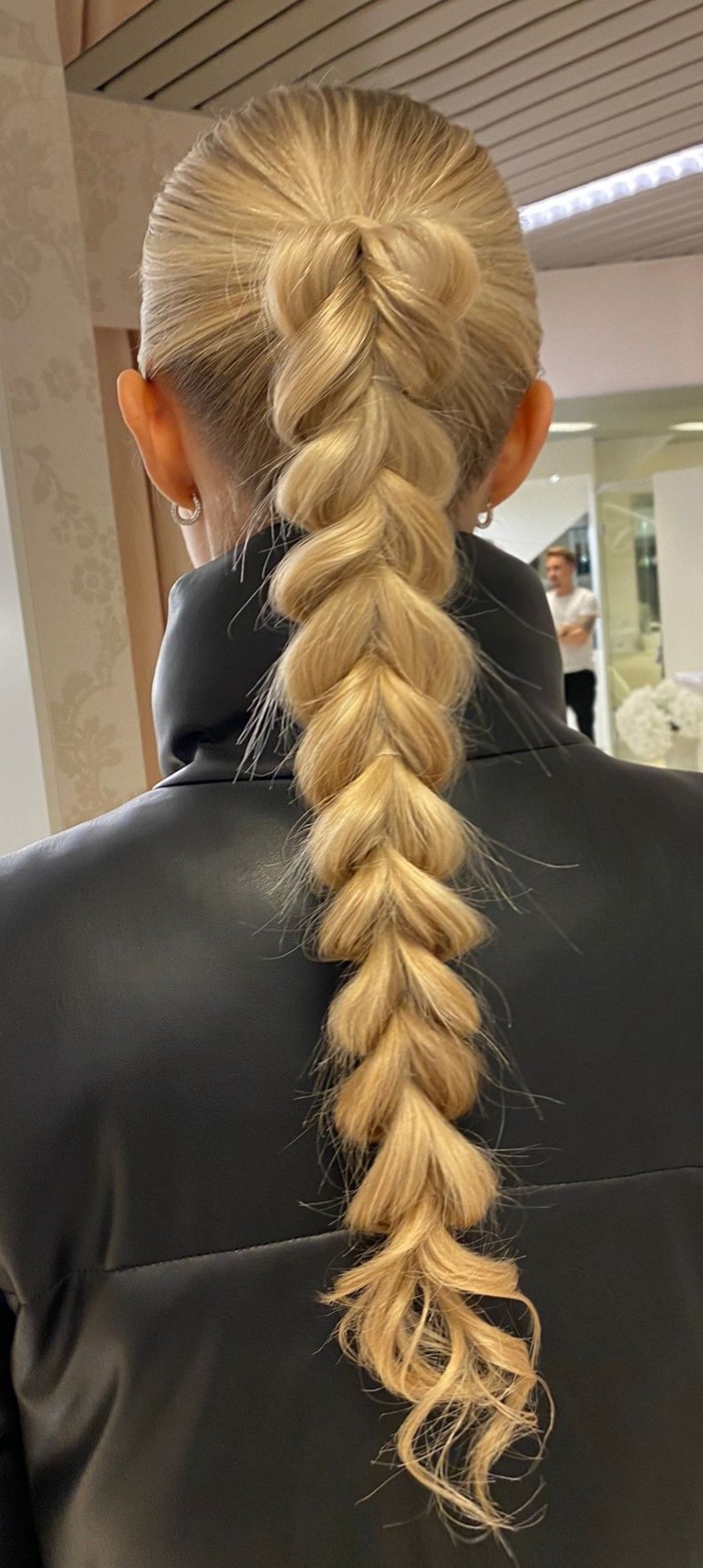 Pour créer ce look élégant, il faut prendre deux sections de cheveux, une à gauche et une à droite et ramener la mèche de gauche vers la gauche et la mèche de droite vers la droite. Il faut ensuite rassembler ces deux mèches en dessous de la troisième mèche du milieu et les attacher ensemble à l’arrière. 