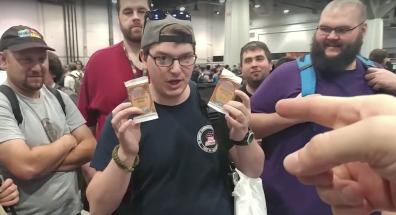 A man holds up a pack of Magic cards at a an event in Las Vegas.YouTube