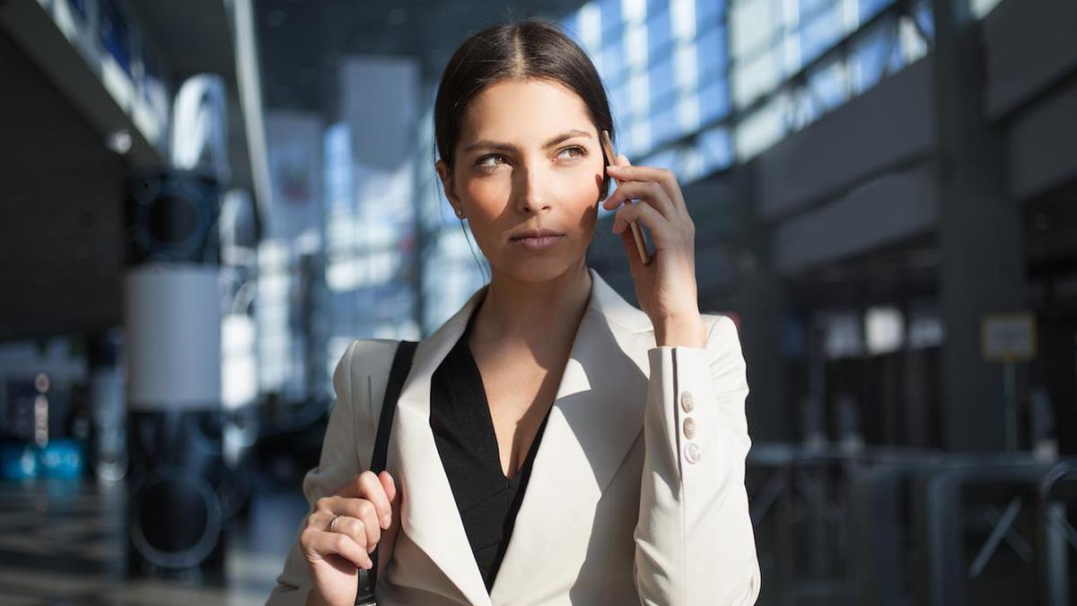 Concentrated woman talking on phone in office