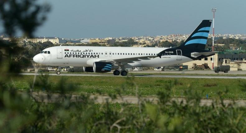 A picture taken on December 23, 2016 shows a Malta armed forces truck sitting by the Afriqiyah Airways A320 after it landed in Valletta, Malta, following its hijacking from Libya