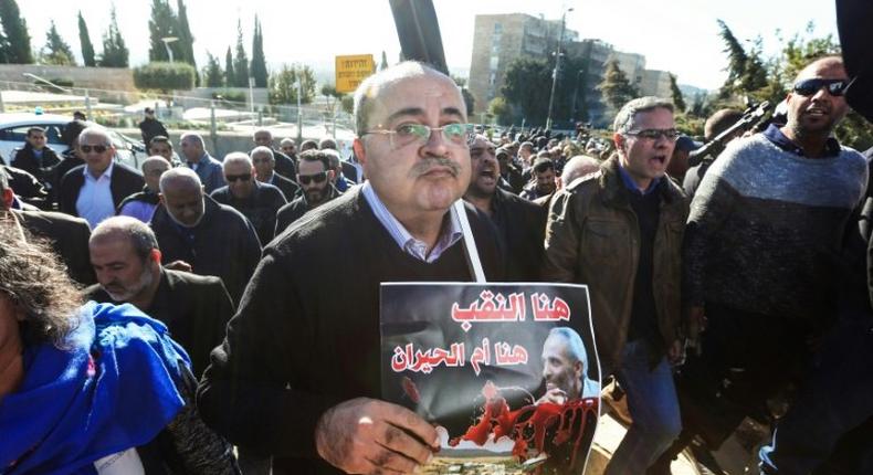 Arab Israeli Knesset (Israeli parliament) member Ahmad Tibi carries a sign in Arabic reading Here is Negev in protest at demolitions carried out by authorities in Arab neighbourhoods, in front of the Knesset in Jerusalem on January 23, 2017