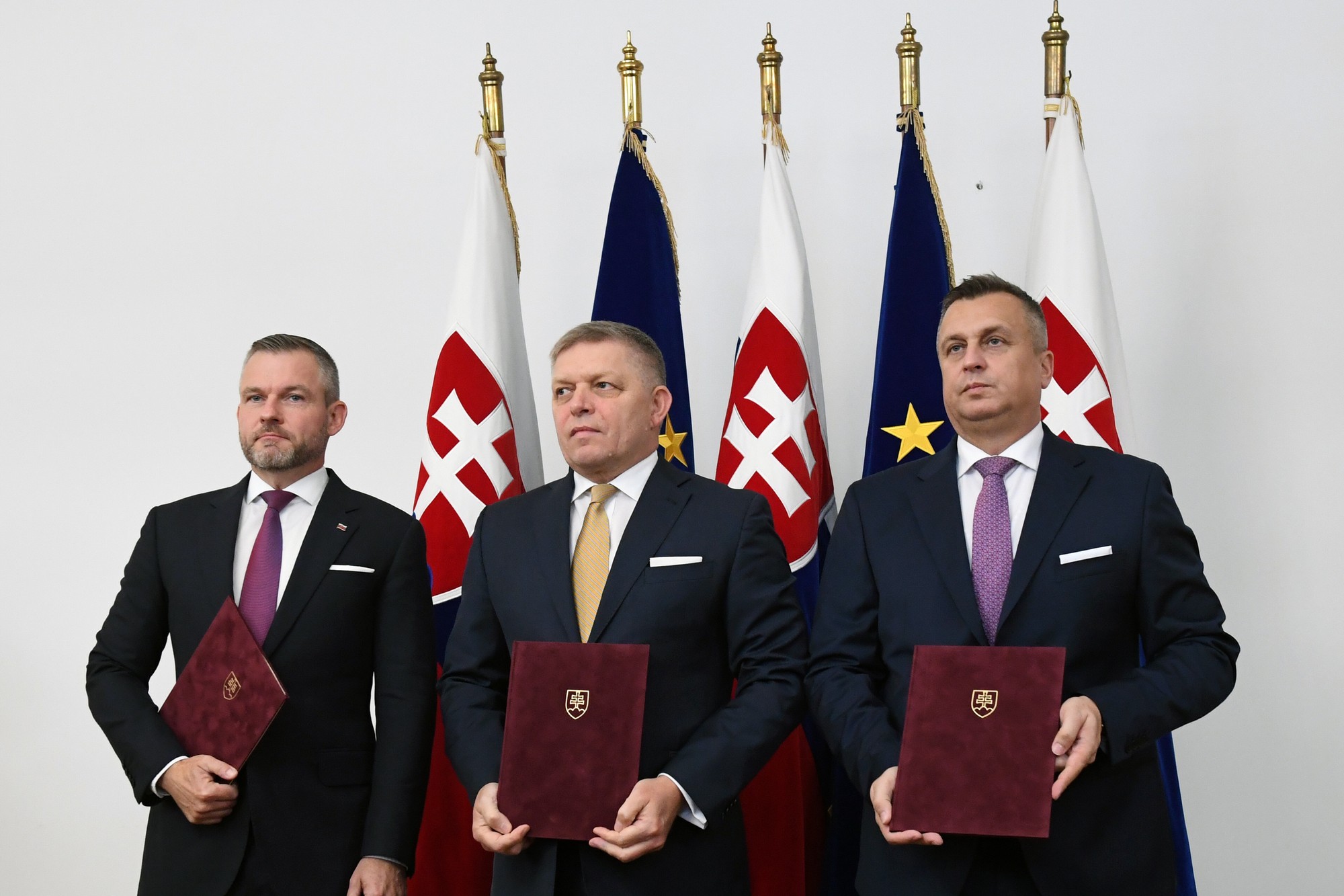 Zľava predseda strany Hlas-SD Peter Pellegrini, predseda Smer-SD Robert Fico a predseda strany SNS Andrej Danko pózujú po podpise koaličnej dohody v Bratislave.