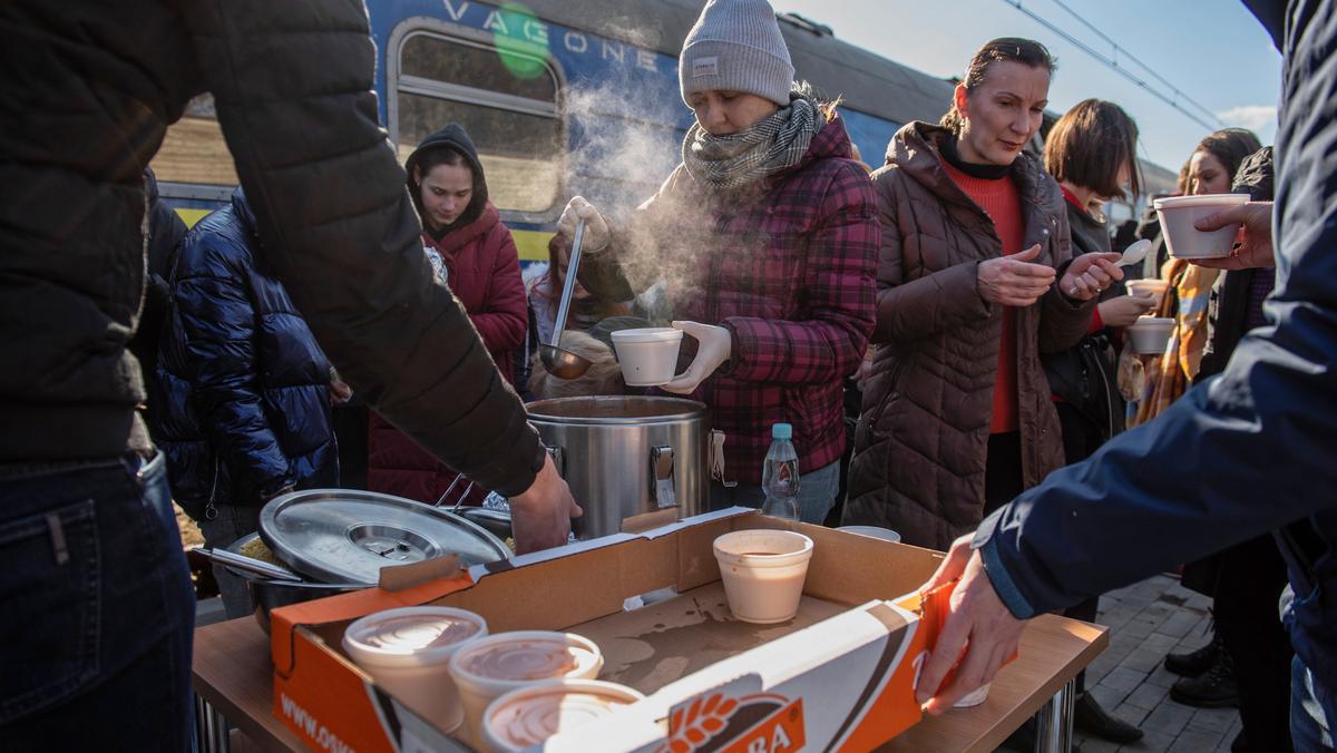 Wydawanie żywności dla uchodźców podróżujących pociągiem relacji Kijów-Warszawa na stacji kolejowej w Dorohusku