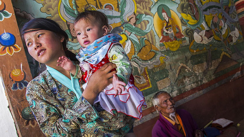 Kobieta z dzieckiem w klasztorze w wiosce Chimi Lhakhang w dolinie Punakha