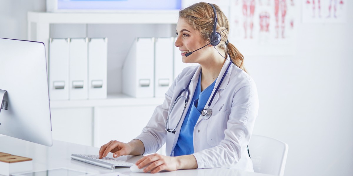 Senior medical physician talking on smart phone and using laptop computer