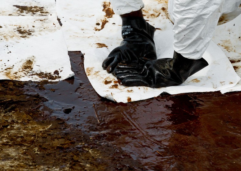 Katastrofa w Zatoce Meksykańskiej: Grand Isle, Louisiana, USA. Pracownicy zatrudnieni przez koncern BP przy użyciu wchłaniających ropę szmat czyszczą plażę z resztek czarnej mazi. Foto: Derick E. Hingle/Bloomberg