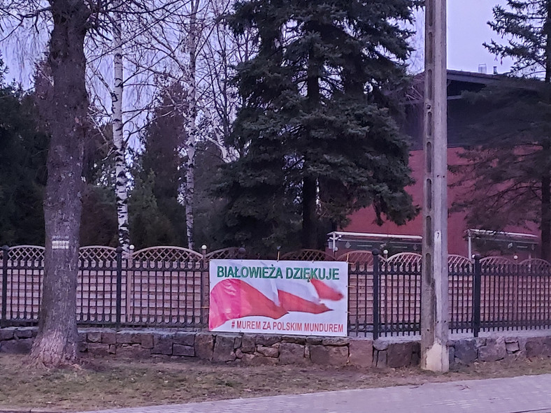 Baner na ogrodzeniu jednego z hoteli w Białowieży, w którym stacjonują żołnierze