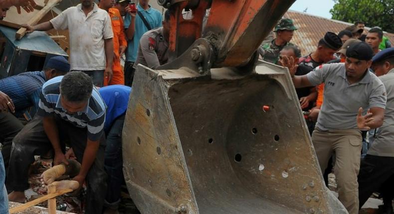 Residents rescue an earthquake survivor from rubble in Pidie Jaya, Indonesia's Aceh province, on December 7, 2016